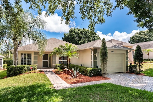 single story home featuring a garage and a front lawn