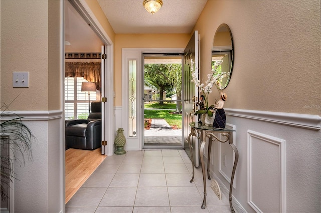 entryway featuring a textured ceiling and light tile floors