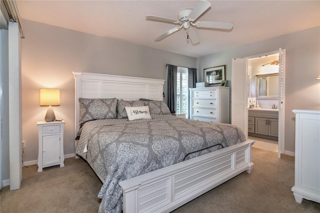 carpeted bedroom with ceiling fan and ensuite bath