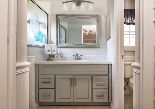 bathroom featuring tile flooring, toilet, and vanity