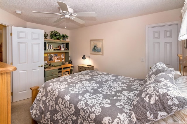 carpeted bedroom featuring ceiling fan and a textured ceiling