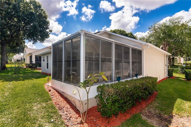 view of home's exterior featuring a sunroom and a yard