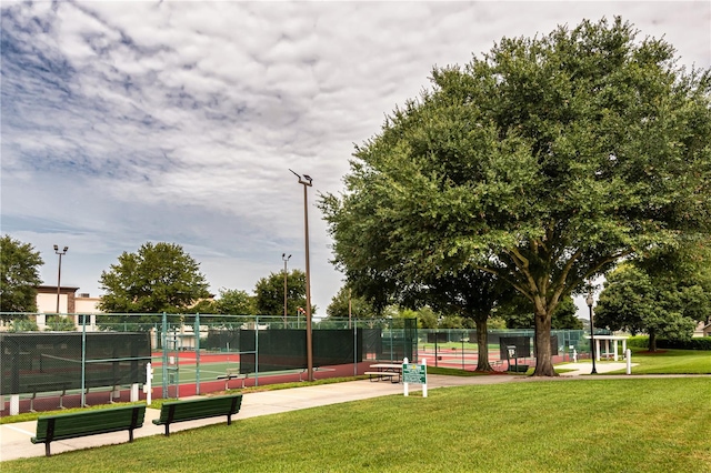 view of tennis court featuring a lawn