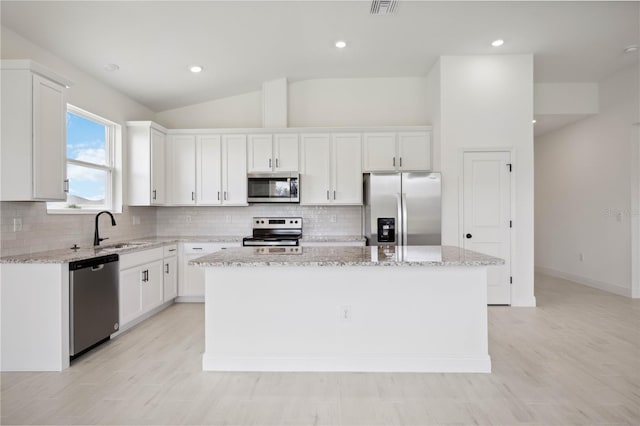 kitchen with sink, white cabinetry, appliances with stainless steel finishes, and a center island