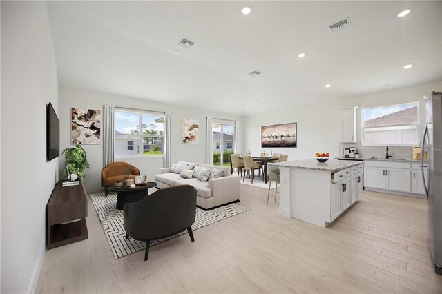 living room featuring sink and light hardwood / wood-style floors