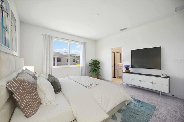 bedroom featuring light colored carpet and ensuite bath