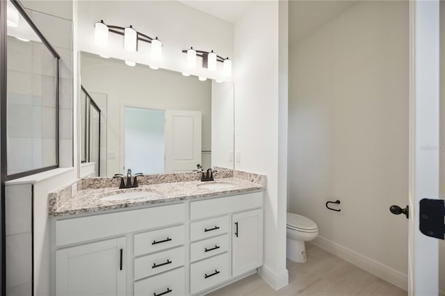 bathroom with toilet, a shower with door, hardwood / wood-style flooring, and vanity