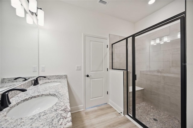 bathroom with vanity, a shower with shower door, and hardwood / wood-style floors