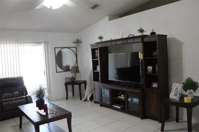 tiled living room with ceiling fan and lofted ceiling