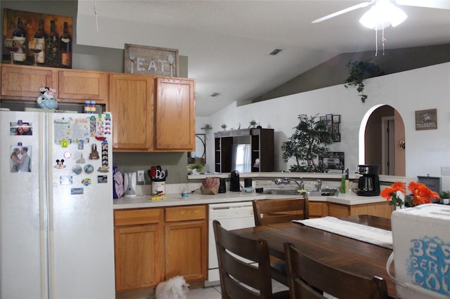 kitchen featuring ceiling fan, kitchen peninsula, white appliances, sink, and lofted ceiling