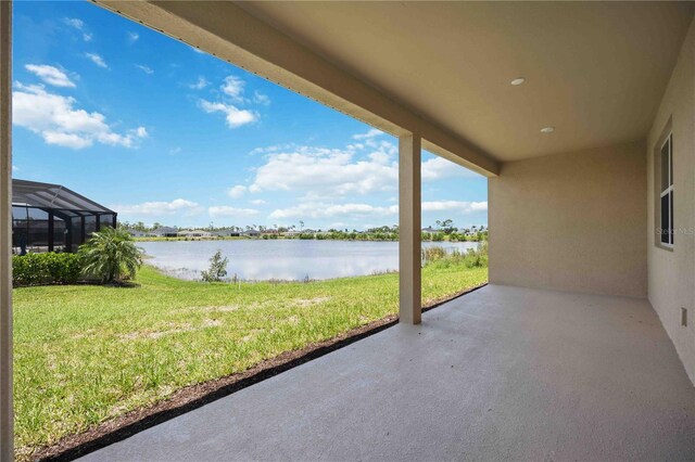 view of patio with a water view and glass enclosure