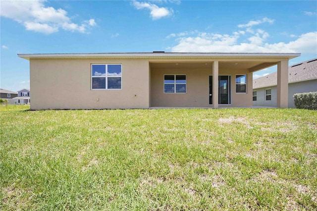 rear view of house featuring a yard