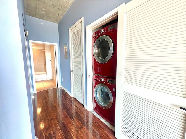 laundry room with stacked washing maching and dryer and dark hardwood / wood-style floors