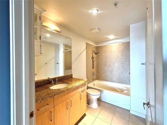 full bathroom featuring toilet, vanity, tile patterned floors, and tiled shower / bath combo