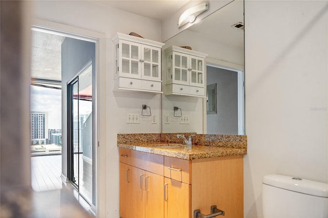 kitchen featuring light stone counters, light brown cabinets, and sink