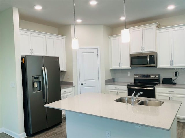 kitchen with sink, white cabinets, stainless steel appliances, and decorative light fixtures