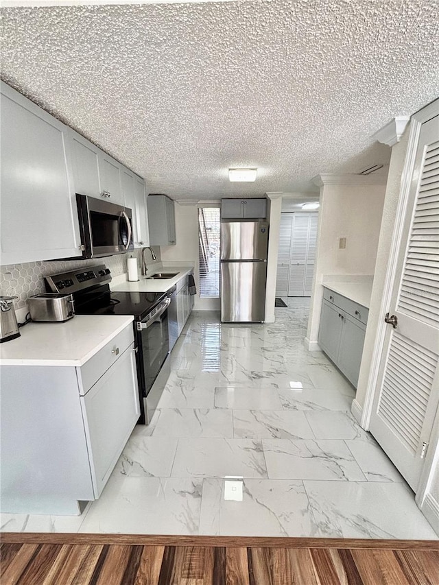 kitchen with stainless steel appliances, sink, and gray cabinetry