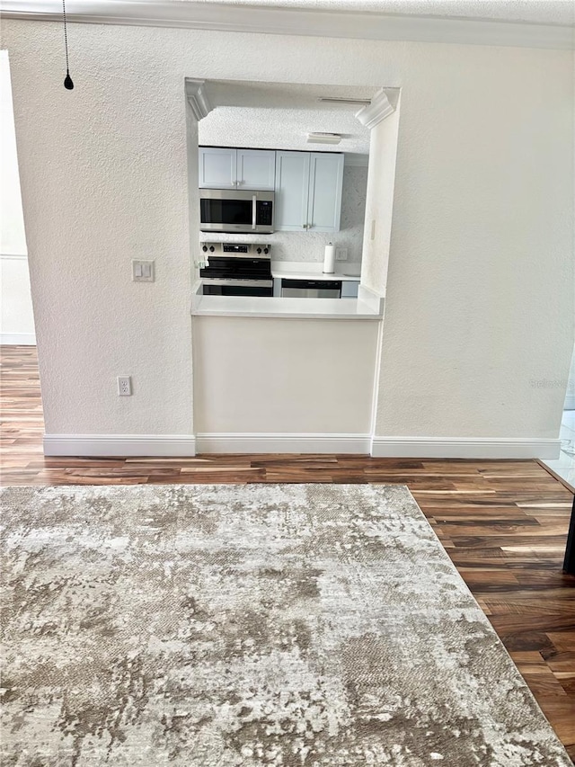 interior space with crown molding, dark hardwood / wood-style floors, and a textured ceiling