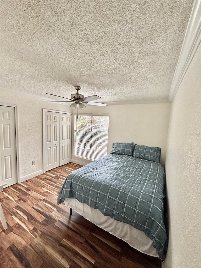 bedroom featuring crown molding, ceiling fan, wood-type flooring, and a textured ceiling