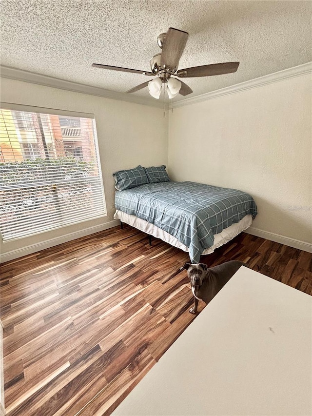 bedroom with hardwood / wood-style flooring, ornamental molding, a textured ceiling, and ceiling fan