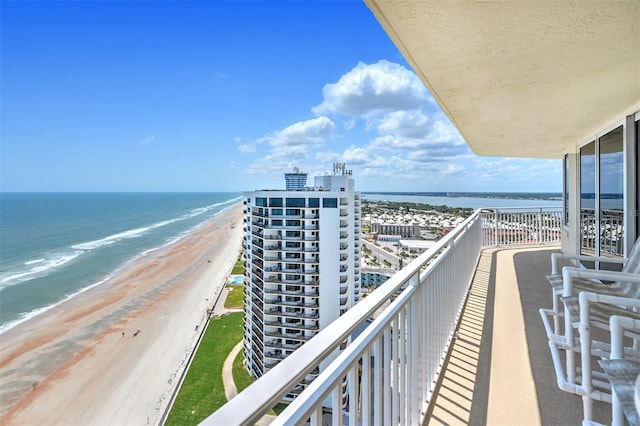 balcony featuring a view of the beach and a water view