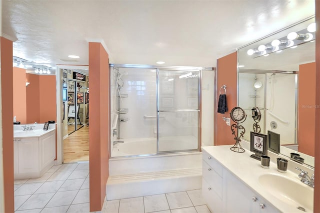 bathroom featuring tile flooring, combined bath / shower with glass door, vanity, and crown molding