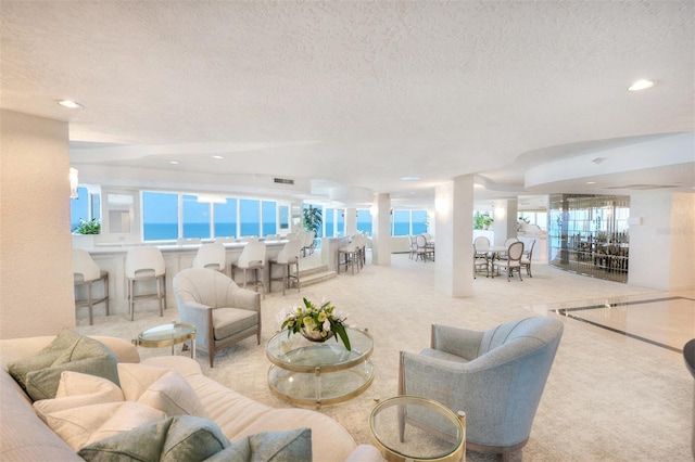 living room with a textured ceiling and light colored carpet