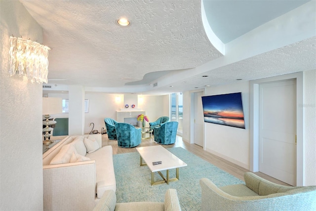 living room with a wealth of natural light, hardwood / wood-style floors, and a textured ceiling