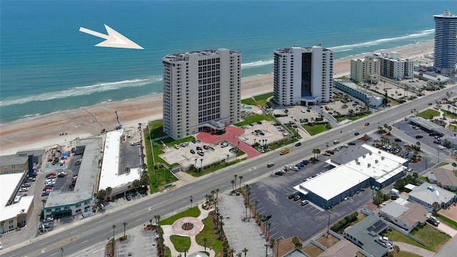 birds eye view of property featuring a beach view and a water view