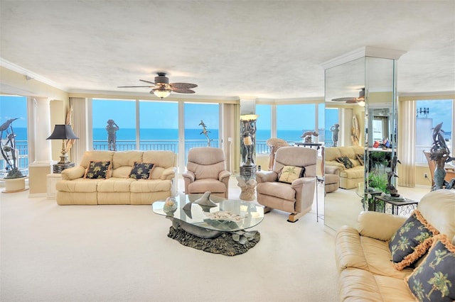 living room with a water view, carpet, ceiling fan, and expansive windows