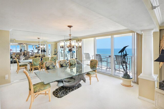 carpeted dining space featuring a chandelier, ornate columns, and a water view