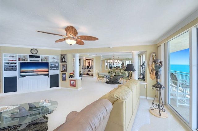 living room with a water view, ornamental molding, decorative columns, and ceiling fan with notable chandelier