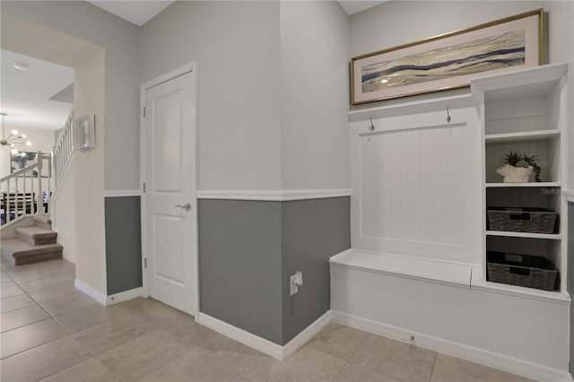 mudroom with a chandelier and light tile floors