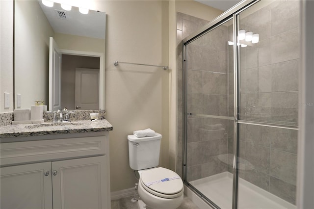 bathroom with vanity, toilet, and a shower with door