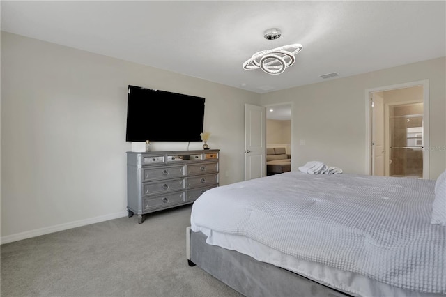 bedroom featuring light colored carpet and ensuite bathroom