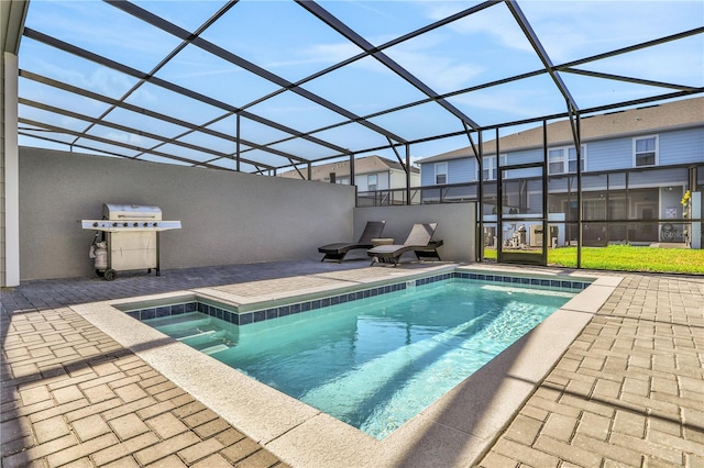 view of pool featuring glass enclosure and a patio area