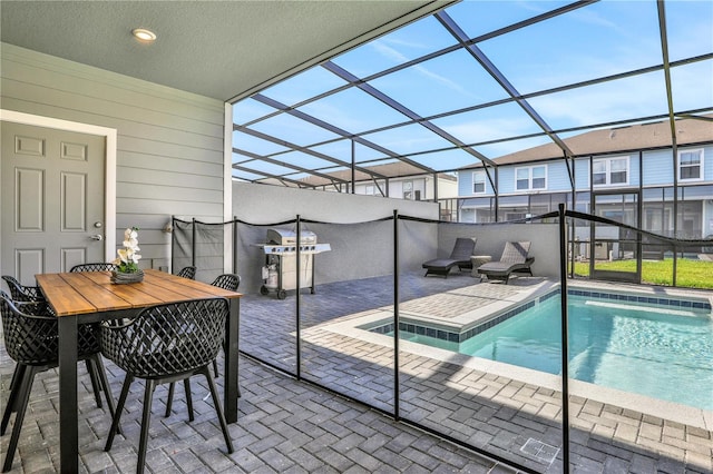 view of pool with glass enclosure and a patio area