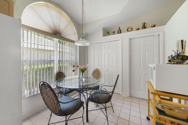 tiled dining area featuring lofted ceiling