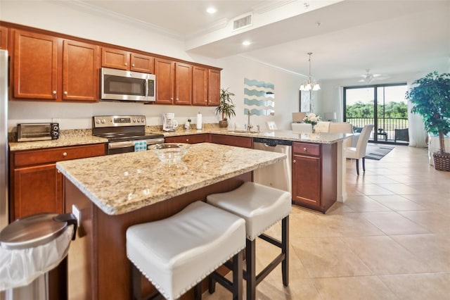 kitchen featuring kitchen peninsula, appliances with stainless steel finishes, ceiling fan with notable chandelier, sink, and decorative light fixtures