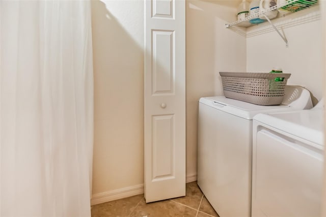 washroom with light tile patterned floors and washer and clothes dryer