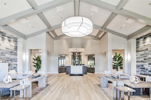 living room featuring beam ceiling, light hardwood / wood-style floors, and high vaulted ceiling