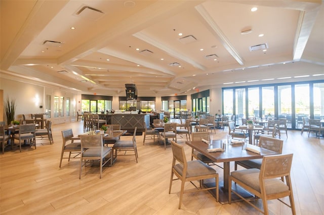 dining area featuring beam ceiling, light wood-type flooring, and ornamental molding