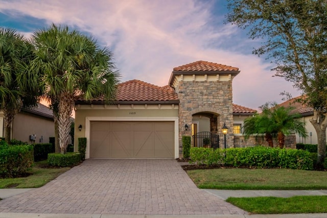 mediterranean / spanish home with a lawn and a garage