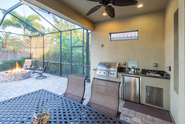 sunroom featuring ceiling fan and sink