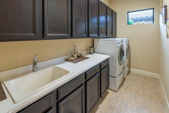 laundry area featuring sink, cabinets, light tile patterned flooring, and washer and clothes dryer