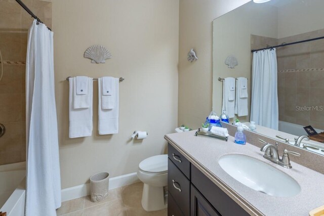 full bathroom featuring tile patterned flooring, toilet, shower / bath combo with shower curtain, and vanity