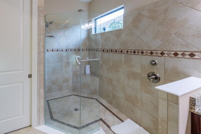 bathroom featuring tile patterned flooring, an enclosed shower, and vanity