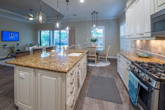 kitchen with backsplash, sink, stone counters, an island with sink, and dark hardwood / wood-style floors