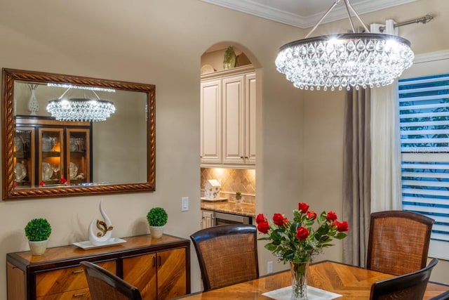 dining space with ornamental molding and a chandelier