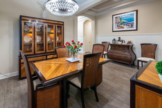 dining area with an inviting chandelier, crown molding, and hardwood / wood-style floors